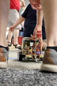 Ein Student setzt den autonom fahrenden Roboter auf die Startlinie.