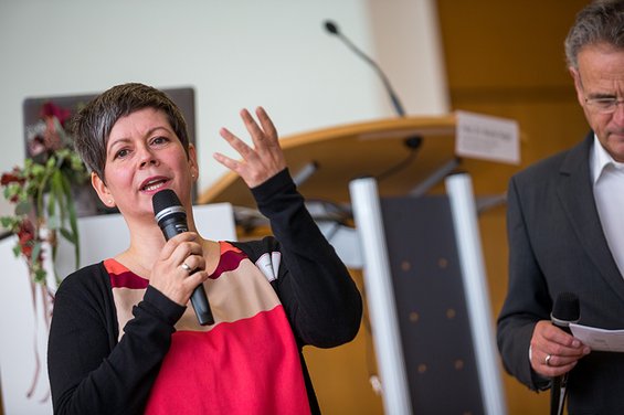Eine Frau mit Mikrofon redet bei einer Veranstaltung