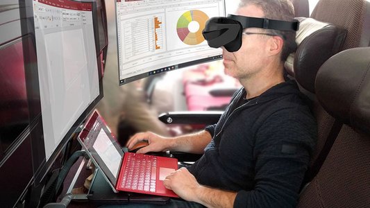 Mensch im Zug mit Laptop und virtuellen Bildschirmen