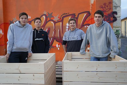 Vier Schüler mit den selbst gebauten Hochbeeten