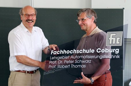 Prof. Peter Schwarz überreicht Prof. Thomas Büroschild