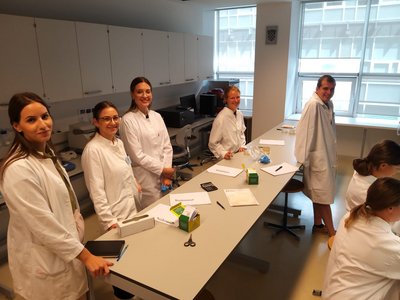 Junge Leute in weißen Kitteln in einem Labor.
