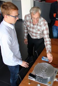 Jonas Göbel und Christian Wolf vor dem Modell des Teilchenbeschleunigers