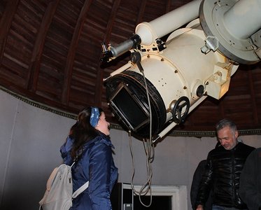 Eine Studentin schaut durch ein Teleskop in den Himmel