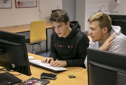 Zwei Elektrotechnik-Studenten lösen eine Aufgabe am Computer