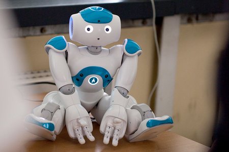 Der humanoide Roboter NAO sitzt auf einem Tisch
