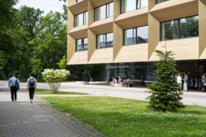 Young people walk past a building with a golden façade