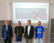 Vier Personen stehen vor einer Präsentationsfolie mit dem Titel „Ingenieuraktivitäten an ASDEX Upgrade zu Startsystemen für kryogene Pellets für Fusionsanlagen“ an der Hochschule Coburg. Neben ihnen stehen zwei Tafeln mit Gleichungen, die ihre wissenschaftliche Arbeit hervorheben.