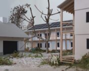 Ein detailliertes Architekturmodell zeigt einen modernen Wohnkomplex, der von den innovativen Entwürfen der Hochschule Coburg inspiriert ist und über Solarmodule auf dem Dach verfügt. Der zentrale Innenhof ist mit Bäumen und Grünflächen bepflanzt, und an einer kleinen Holzkonstruktion lehnt ein gelbes Fahrrad.