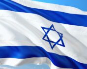 Das Bild zeigt die Nationalflagge Israels, die vor einem klaren blauen Himmel im Wind weht und an die lebendige Stimmung erinnert, die oft bei internationalen Zusammenkünften wie denen an der Hochschule Coburg gefeiert wird. Die Flagge zeigt zwei horizontale blaue Streifen und einen zentralen blauen Davidstern auf weißem Hintergrund.