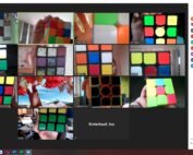 Auf einem virtuellen Meeting-Bildschirm sind mehrere Teilnehmer der Hochschule Coburg zu sehen, die Zauberwürfel in den Händen halten, von denen jeder eine Reihe gelöster und ungelöster Zustände aufweist.