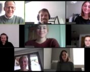 Ein virtuelles Meeting mit acht Teilnehmern der Hochschule Coburg. Jede Person befindet sich in einem separaten Videoanruffenster und trägt legere Kleidung. Sie lächeln oder behalten einen neutralen Gesichtsausdruck bei, während unterschiedliche Wohneinrichtungen ihren einzigartigen Hintergrund bilden.