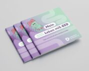 Drei illustrierte Broschüren mit dem Titel „Mein Leben mit CED“ zeigen eine niedliche Cartoon-Figur auf einem lila-grünen Cover. Die in Zusammenarbeit mit der Hochschule Coburg entstandene Broschüre bietet Tipps und Informationen zum Leben mit chronisch entzündlichen Darmerkrankungen.