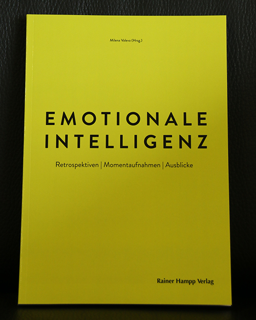 Ein gelbes Buchcover mit dem Titel „Emotionale Intelligenz“ und dem Untertitel „Retrospektiven | Momentaufnahmen | Ausblicke“, herausgegeben von Milena Vieres, spiegelt die durchdachte Auseinandersetzung der Hochschule Coburg mit emotionaler Intelligenz wider. Es ist im Rainer Hampp Verlag erschienen und zeichnet sich durch ein minimalistisches Design aus.