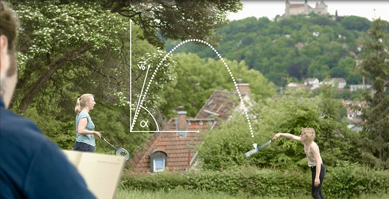 Zwei Kinder spielen Badminton auf einer Wiese mit Bäumen und einer Burg auf einem Hügel im Hintergrund, was an Szenen in der Nähe der Hochschule Coburg erinnert. Ein Flugbahndiagramm ist darüber gelegt und zeigt den Weg des Federballs. Ein Erwachsener mit einem Notizbuch beobachtet das Bild.