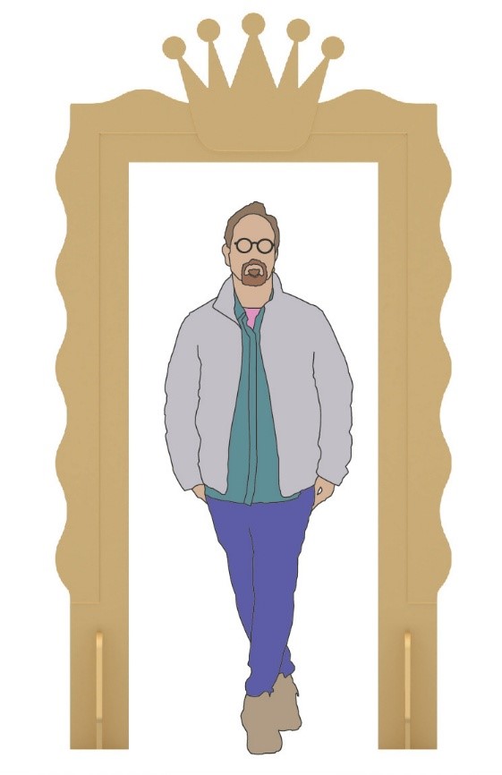 Eine Person mit Brille und Bart, bekleidet mit Jacke, Hemd und Hose, steht lässig mit übereinandergeschlagenen Beinen in einem großen goldenen Rahmen mit gewellten Rändern und einer Krone obenauf an der Hochschule Coburg. at Hochschule Coburg