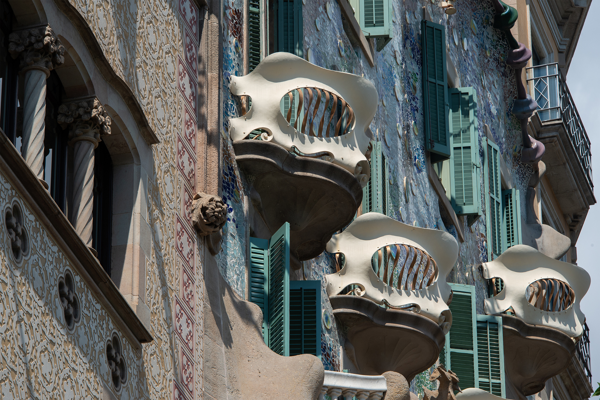 Nahaufnahme der Fassade der Casa Batlló in Barcelona, die Gaudís unverwechselbare Architektur mit knochenartigen Balkonen, lebhaften Mosaikfliesen und grünen Fensterläden hervorhebt - ein ikonisches Beispiel für innovatives Design. at Hochschule Coburg