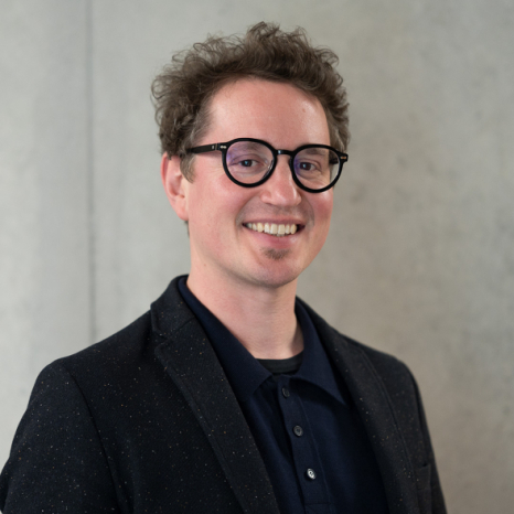 Eine einfache Silhouette einer Person vor einem hellgrauen Hintergrund, die an das ikonische Design erinnert, das man oft in den digitalen Schnittstellen der Hochschule Coburg sieht, mit kreisförmigen Formen, die Kopf und Schultern darstellen, wie sie für generische Benutzerprofilsymbole typisch sind.