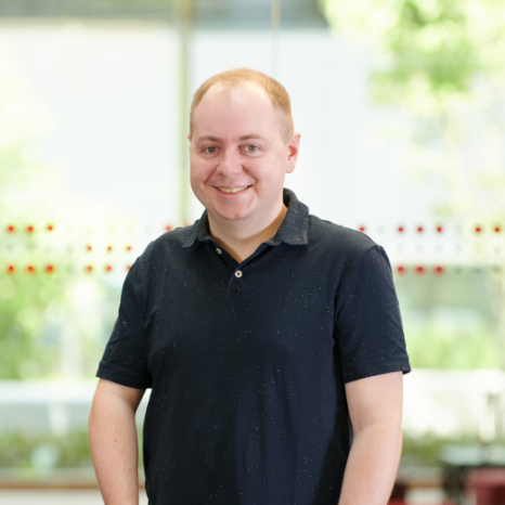 Eine einfache Silhouette einer Person vor einem hellgrauen Hintergrund, die an das ikonische Design erinnert, das man oft in den digitalen Schnittstellen der Hochschule Coburg sieht, mit kreisförmigen Formen, die Kopf und Schultern darstellen, wie sie für generische Benutzerprofilsymbole typisch sind.