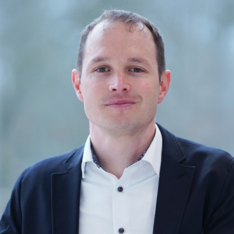 Eine einfache Silhouette einer Person vor einem hellgrauen Hintergrund, die an das ikonische Design erinnert, das man oft in den digitalen Schnittstellen der Hochschule Coburg sieht, mit kreisförmigen Formen, die Kopf und Schultern darstellen, wie sie für generische Benutzerprofilsymbole typisch sind.