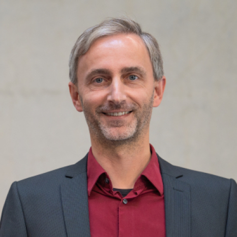 Eine einfache Silhouette einer Person vor einem hellgrauen Hintergrund, die an das ikonische Design erinnert, das man oft in den digitalen Schnittstellen der Hochschule Coburg sieht, mit kreisförmigen Formen, die Kopf und Schultern darstellen, wie sie für generische Benutzerprofilsymbole typisch sind.