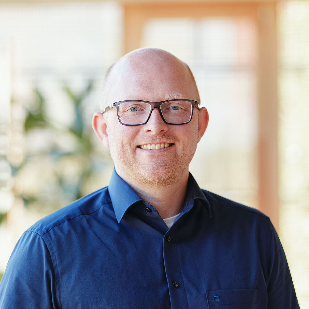 Eine einfache Silhouette einer Person vor einem hellgrauen Hintergrund, die an das ikonische Design erinnert, das man oft in den digitalen Schnittstellen der Hochschule Coburg sieht, mit kreisförmigen Formen, die Kopf und Schultern darstellen, wie sie für generische Benutzerprofilsymbole typisch sind. Michaela Mustermann