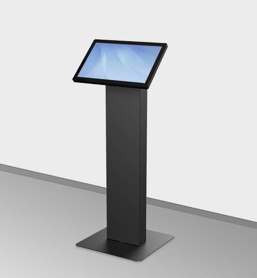 A freestanding digital touchscreen kiosk with a rectangular screen on a tall, slim, black pedestal base—ideal for service centers—positioned on a flat surface against a plain wall. at Hochschule Coburg
