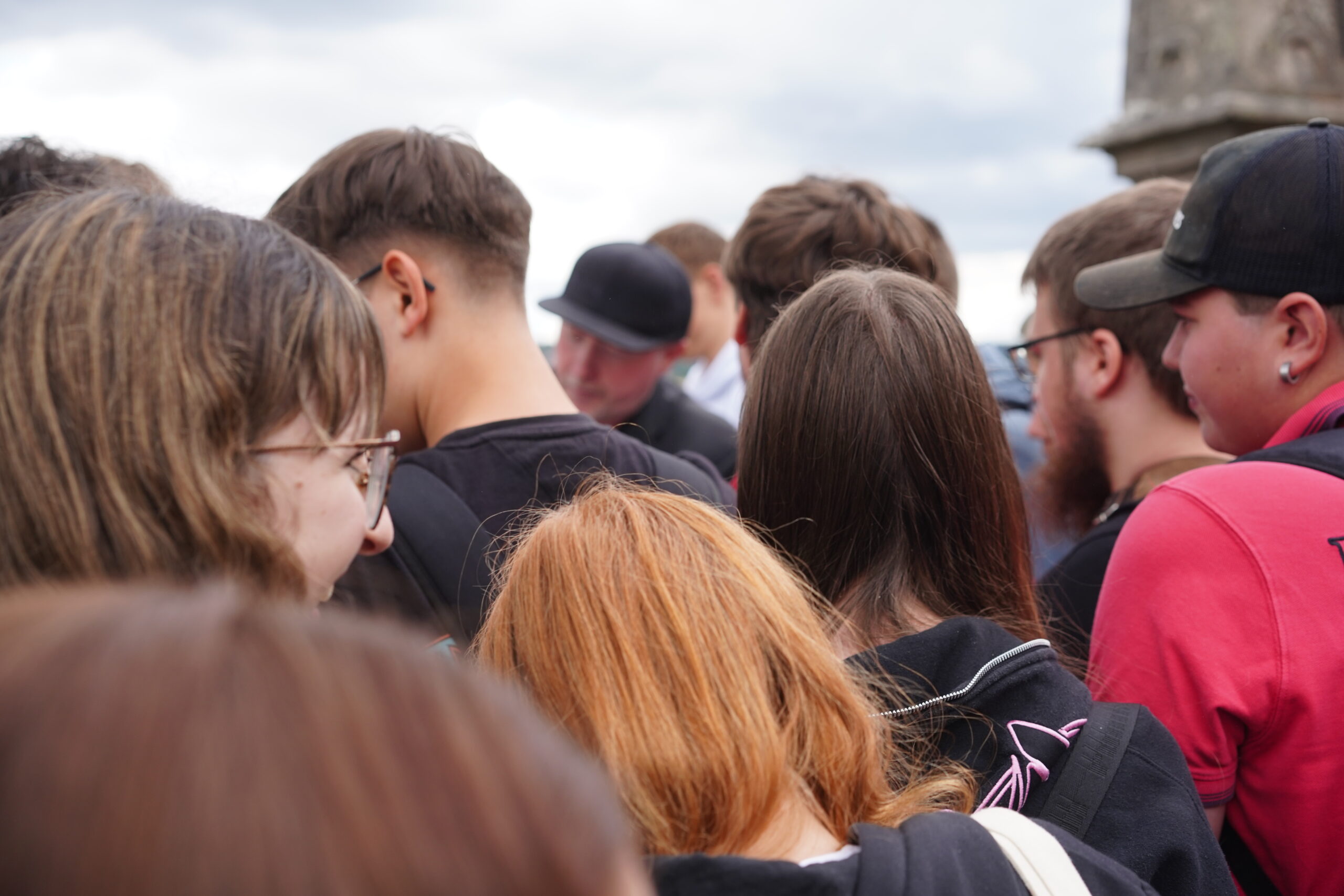 Eine Gruppe von Menschen, darunter mehrere Jugendliche, steht im Freien in Kronach dicht beieinander; die meisten von ihnen haben der Kamera den Rücken zugewandt. Die Gruppe scheint sich zu einer Veranstaltung oder Aktivität versammelt zu haben – vielleicht sogar zu einer mit Joey Kelly –, wobei verschiedene Haarfarben und Freizeitkleidung zu erkennen sind. at Hochschule Coburg