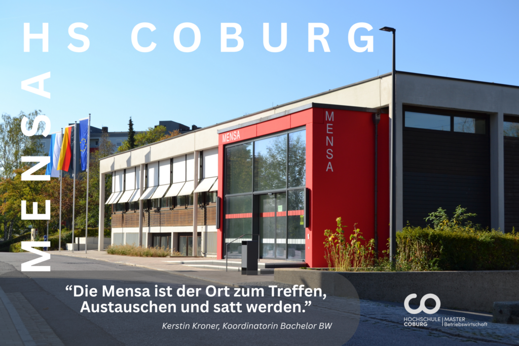 Ein modernes, rot-graues Mensagebäude an der Hochschule Coburg, umgeben von Fahnen und Bäumen, heißt Studierende aller Fachrichtungen, darunter auch der Betriebswirtschaftslehre, willkommen. Unten ist ein Zitat auf Deutsch zu lesen, wonach die Mensa ein Ort der Begegnung, des Austauschs und des Essens ist. at Hochschule Coburg