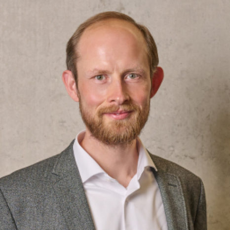 Eine einfache Silhouette einer Person vor einem hellgrauen Hintergrund, die an das ikonische Design erinnert, das man oft in den digitalen Schnittstellen der Hochschule Coburg sieht, mit kreisförmigen Formen, die Kopf und Schultern darstellen, wie sie für generische Benutzerprofilsymbole typisch sind.