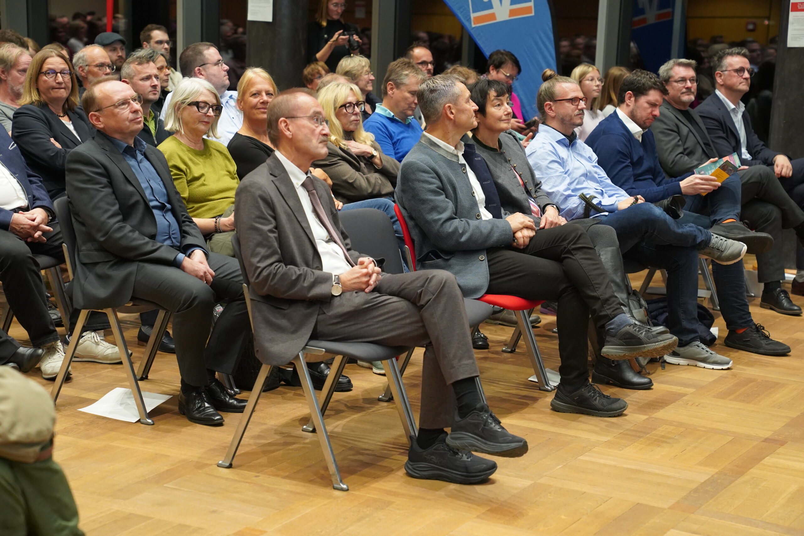Ein Publikum aus Männern und Frauen, die bei einer Konferenz zum Thema „Automatisierung“ in Stuhlreihen sitzen und zur Bühne blicken. at Hochschule Coburg