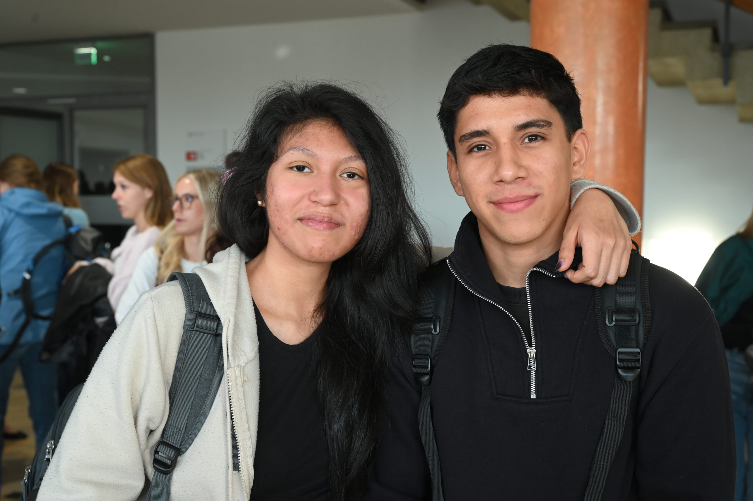 Ein junger Mann und eine junge Frau stehen lächelnd nebeneinander, der Mann hat seinen Arm um ihre Schulter gelegt, und genießen ihre Zeit am Studium Coburg. at Hochschule Coburg