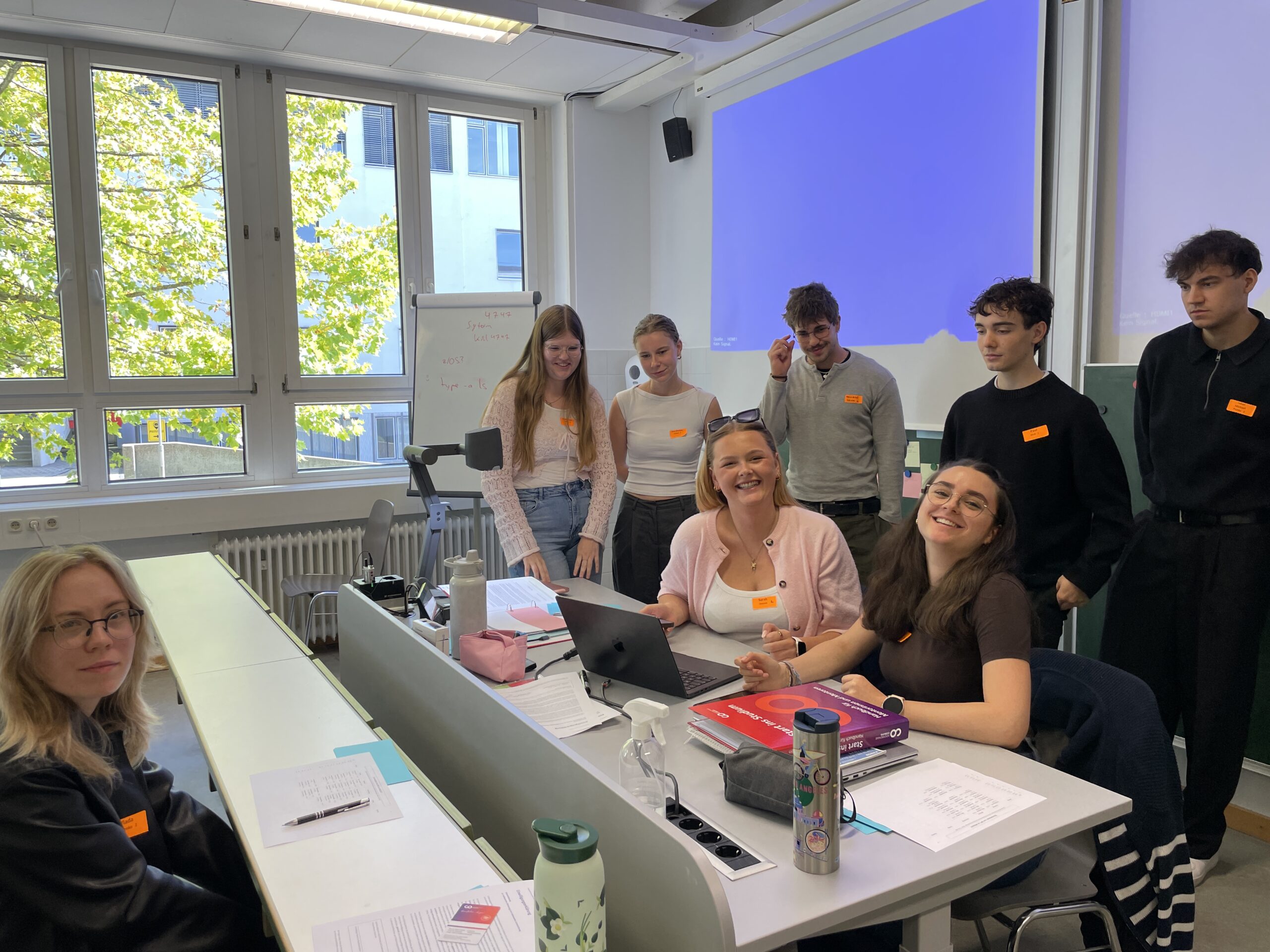 Zu Beginn ihres Studiums versammelte sich eine Gruppe von MINT-Studierenden in einem Hörsaal um einen Tisch, auf dem ein Laptop und Bücher lagen. at Hochschule Coburg