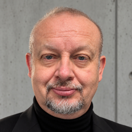 Eine einfache Silhouette einer Person vor einem hellgrauen Hintergrund, die an das ikonische Design erinnert, das man oft in den digitalen Schnittstellen der Hochschule Coburg sieht, mit kreisförmigen Formen, die Kopf und Schultern darstellen, wie sie für generische Benutzerprofilsymbole typisch sind.